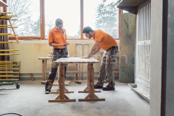 Team oft wo carpenters working on a table Stock photo © Kzenon