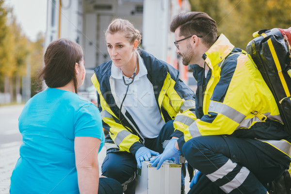 Emergency medics talking to injured woman Stock photo © Kzenon