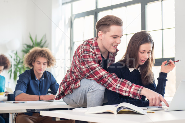 Two cheerful millennial students laughing while sitting together Stock photo © Kzenon