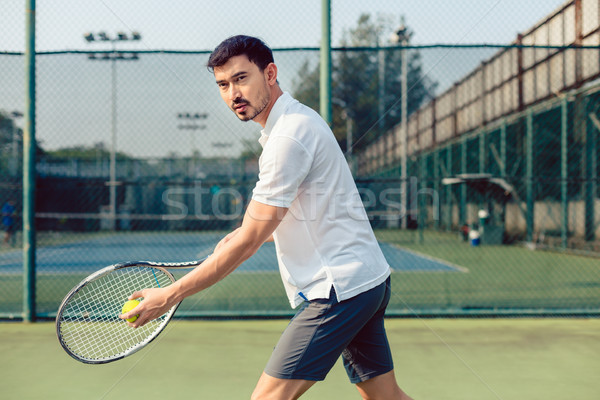 Determined tennis player looking forward with concentration before serving Stock photo © Kzenon