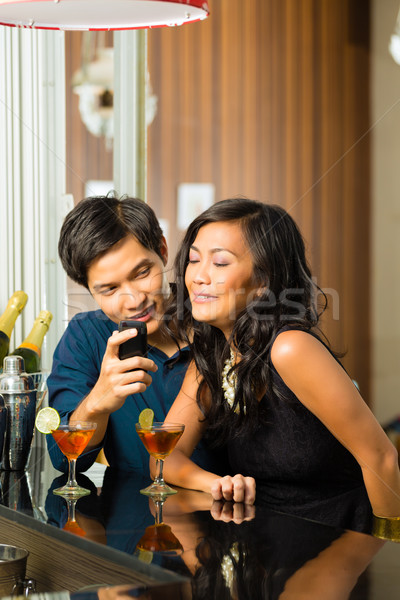 Asian man is flirting with woman in bar Stock photo © Kzenon