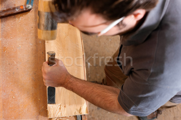 Carpenter with chisel and hammer Stock photo © Kzenon