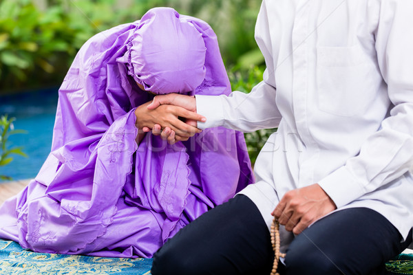 Asian Muslim couple, man and woman, praying at home Stock photo © Kzenon