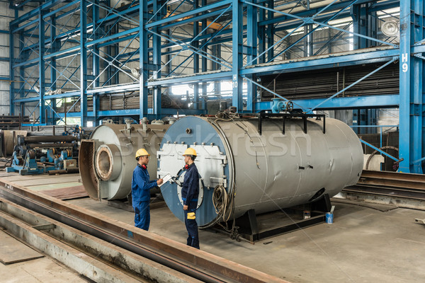 Experienced worker checking the quality of manufactured boilers Stock photo © Kzenon