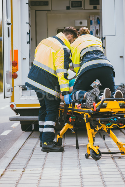 Paramedic on stretcher fighting for life of injured woman Stock photo © Kzenon