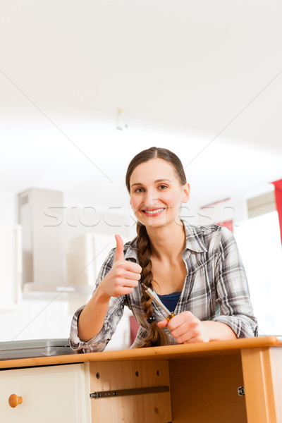Young woman is assembling a cupboard Stock photo © Kzenon