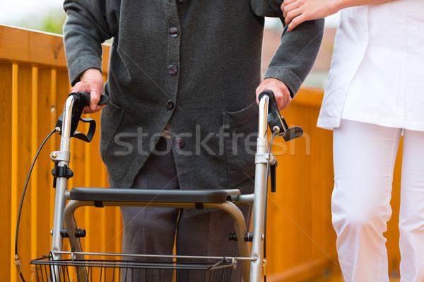 Young nurse and female senior with walking frame Stock photo © Kzenon