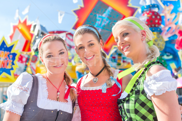 Friends visiting Bavarian fair having fun at carousel  Stock photo © Kzenon