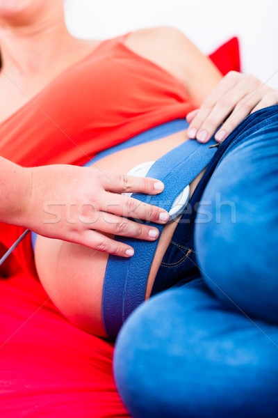 Belly of pregnant women with CTG scanning being adjusted Stock photo © Kzenon