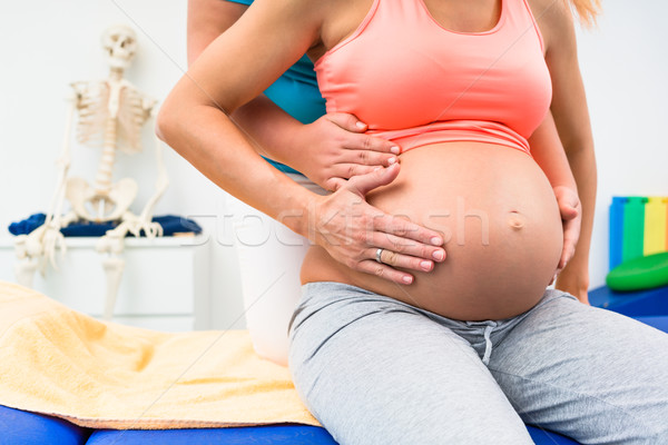 Pregnant woman with physical therapist sitting on couch Stock photo © Kzenon