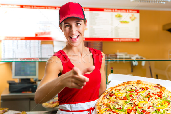 Woman holding a whole pizza in hand Stock photo © Kzenon