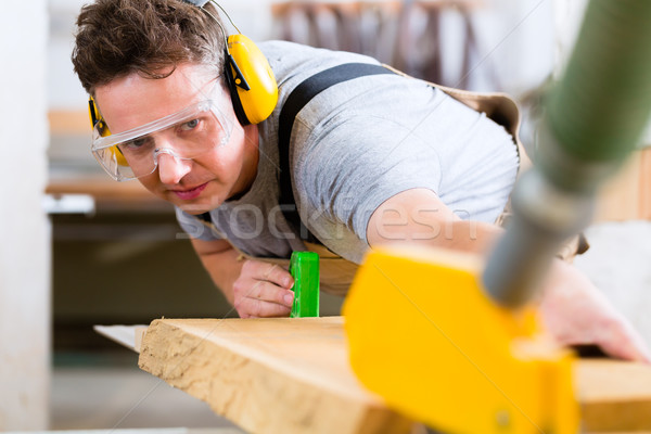Stock photo: Carpenter using electric saw in carpentry