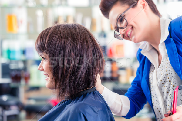Hairdresser cutting woman hair in shop Stock photo © Kzenon