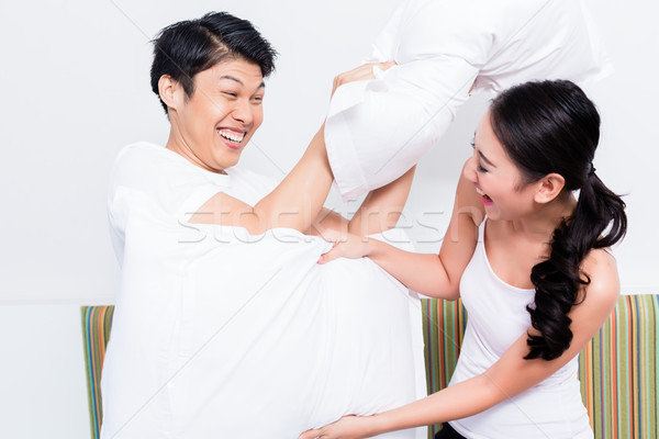 Chinese Woman and man having pillow fight Stock photo © Kzenon