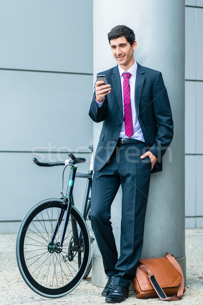 Cheerful young man communicating on mobile phone while waiting o Stock photo © Kzenon