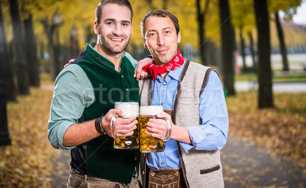 Men in bayrischer Tracht clinking glasses with beer Stock photo © Kzenon