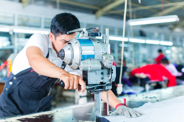 Asian worker using a machine in a factory Stock photo © Kzenon