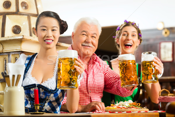 friends drinking beer in Bavarian pub Stock photo © Kzenon