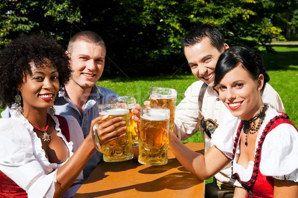 Group of four friends in beer garden Stock photo © Kzenon