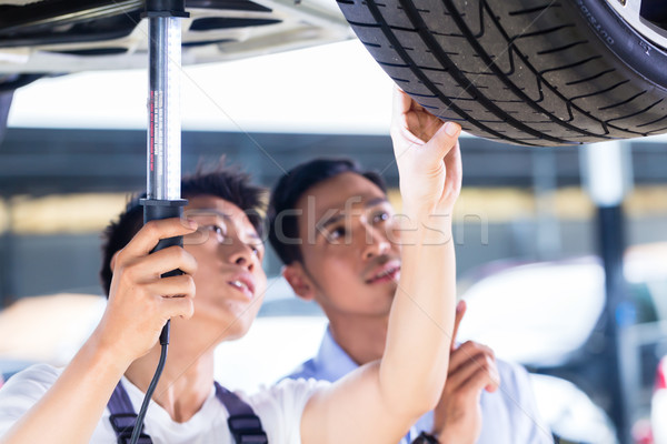 Stock photo: Car mechanic and customer in Asian auto workshop