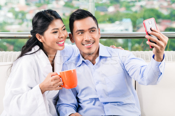 Asian couple taking selfie picture on balcony Stock photo © Kzenon