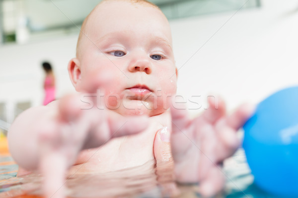 Baby in paddle pond reaching for toy ball in water Stock photo © Kzenon