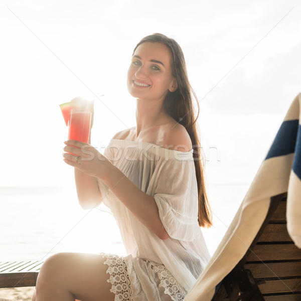Portrait of a beautiful young woman smiling while enjoying a coc Stock photo © Kzenon