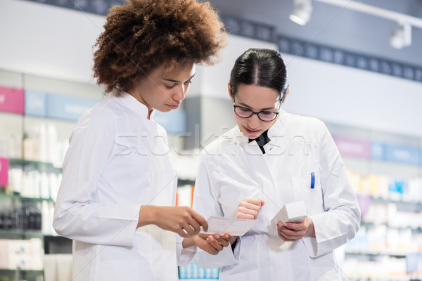 Two pharmacists comparing medicines regarding indications and side effects Stock photo © Kzenon