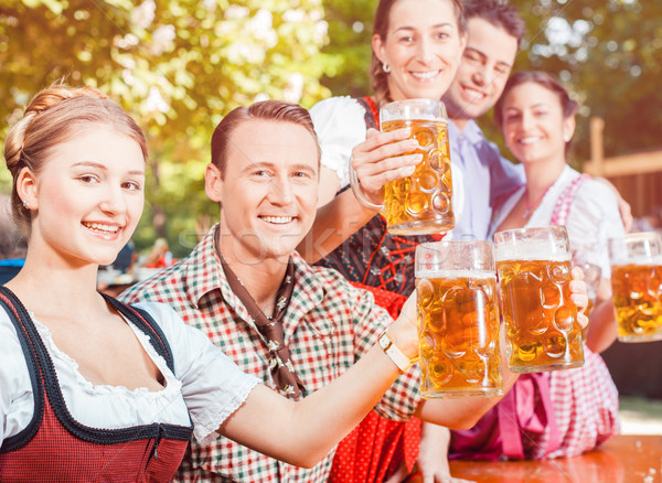 In Beer garden - friends drinking beer in Bavaria on Oktoberfest Stock photo © Kzenon