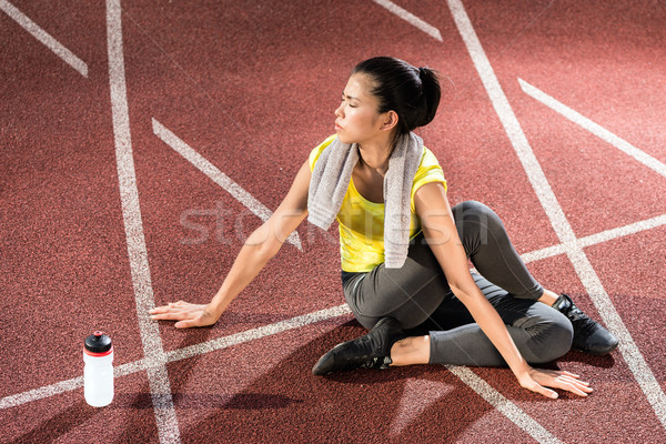 Woman sprinter doing warm up exercise before sprint Stock photo © Kzenon