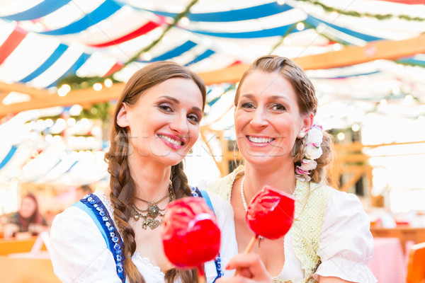 Friends in a beer tent holding candy apples Stock photo © Kzenon
