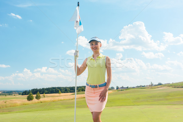 Portrait of a beautiful fit woman holding a flag stick outdoors  Stock photo © Kzenon