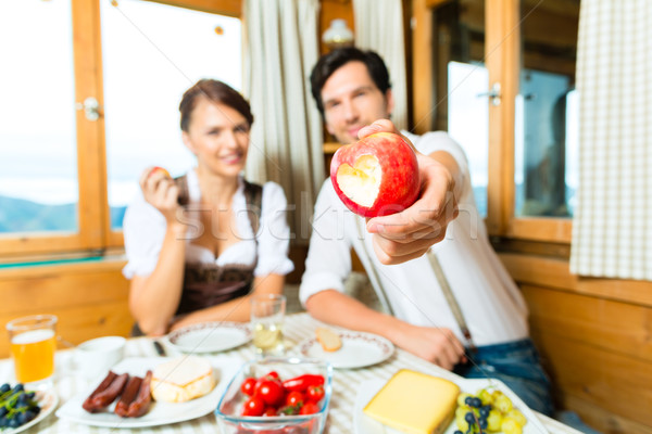 Young couple in mountain chalet eating Stock photo © Kzenon