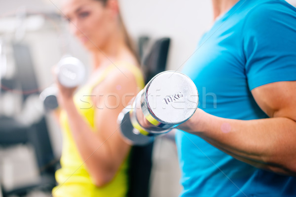 Couple training for fitness in gym with weights Stock photo © Kzenon