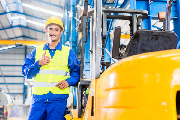 Forklift driver standing in manufacturing plant Stock photo © Kzenon