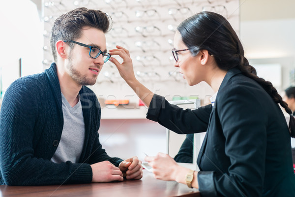 Man in optician shop getting advice from saleswoman Stock photo © Kzenon