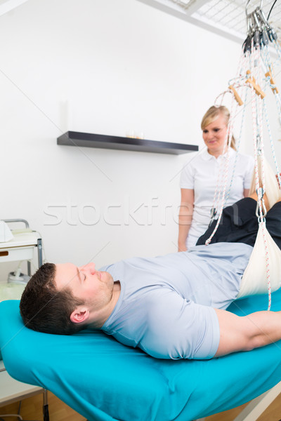 Physiotherapist exercising patient on sling table   Stock photo © Kzenon