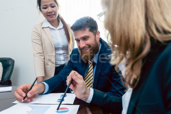 Business analyst smiling while interpreting financial reports sh Stock photo © Kzenon
