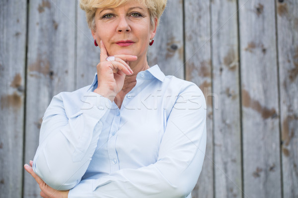 Portrait of an active senior woman looking at camera with a pens Stock photo © Kzenon