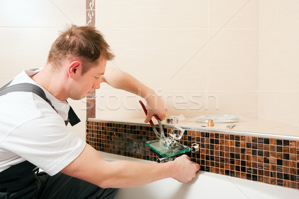 Plumber installing a mixer tap in a bathroom Stock photo © Kzenon