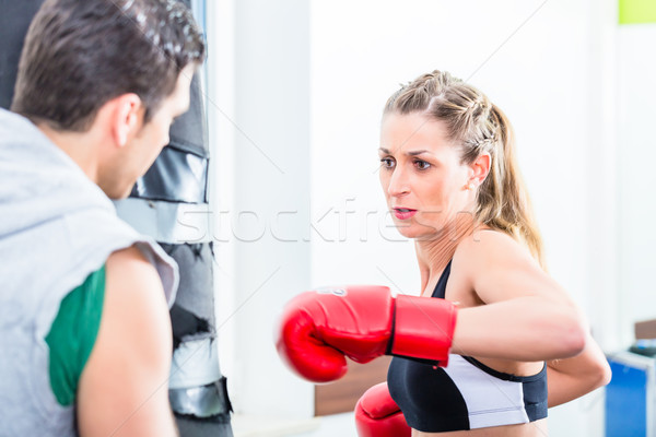 Young woman with trainer in boxing sparring Stock photo © Kzenon