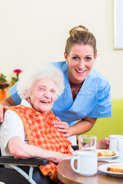 Nurse with senior woman helping with meal Stock photo © Kzenon