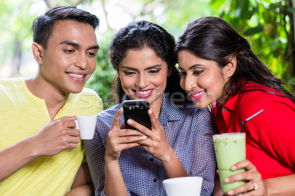 Indian meisje tonen foto's telefoon vrienden Stockfoto © Kzenon