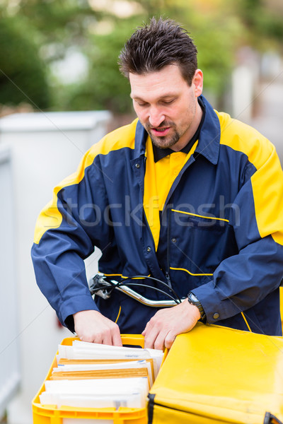 Postman delivering letters to mailbox of recipient Stock photo © Kzenon