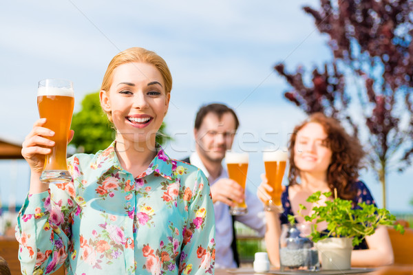 Woman drinking with friends in beer garden Stock photo © Kzenon