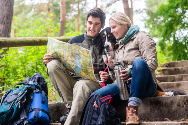 Man and woman on hike planning next route section on map Stock photo © Kzenon