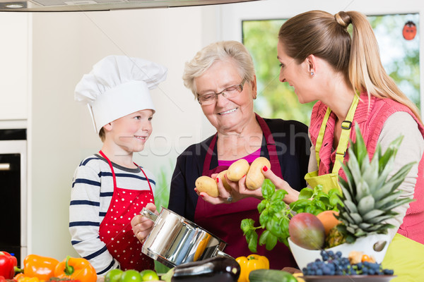 Family cooking in multigenerational household with son, mother,  Stock photo © Kzenon