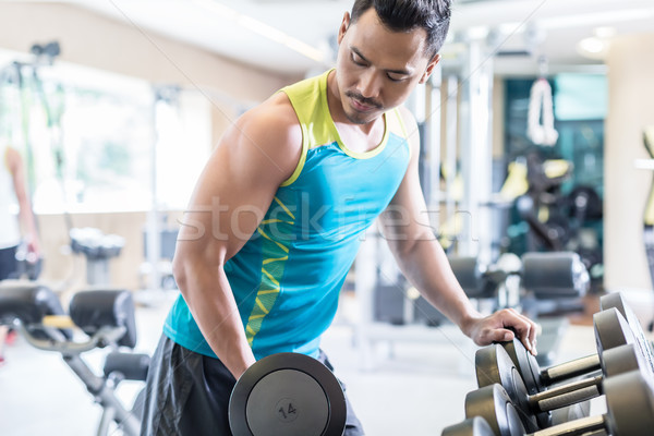 Portrait of a handsome young man exercising bicep curls Stock photo © Kzenon