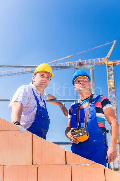 Stock photo: Construction site workers building house with crane