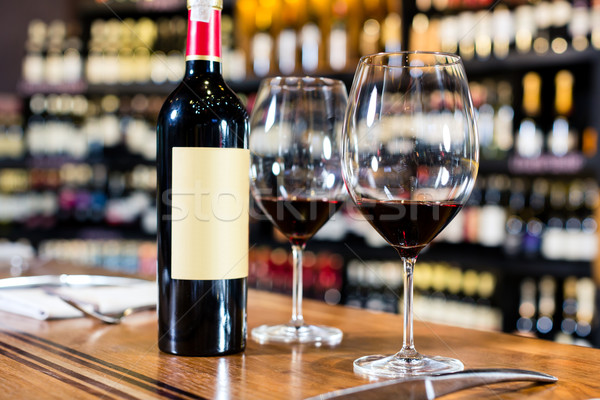 Bottle of red wine and two glasses in wine shop Stock photo © Kzenon